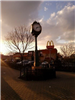 A Park Clock Stands in a Brick Plaza at Sunrise