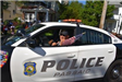 Passaic Police Officer Waving a Small American Flag out of His Cruiser Window