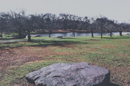 A Lone Flat Boulder in the Middle of a Park Clearing